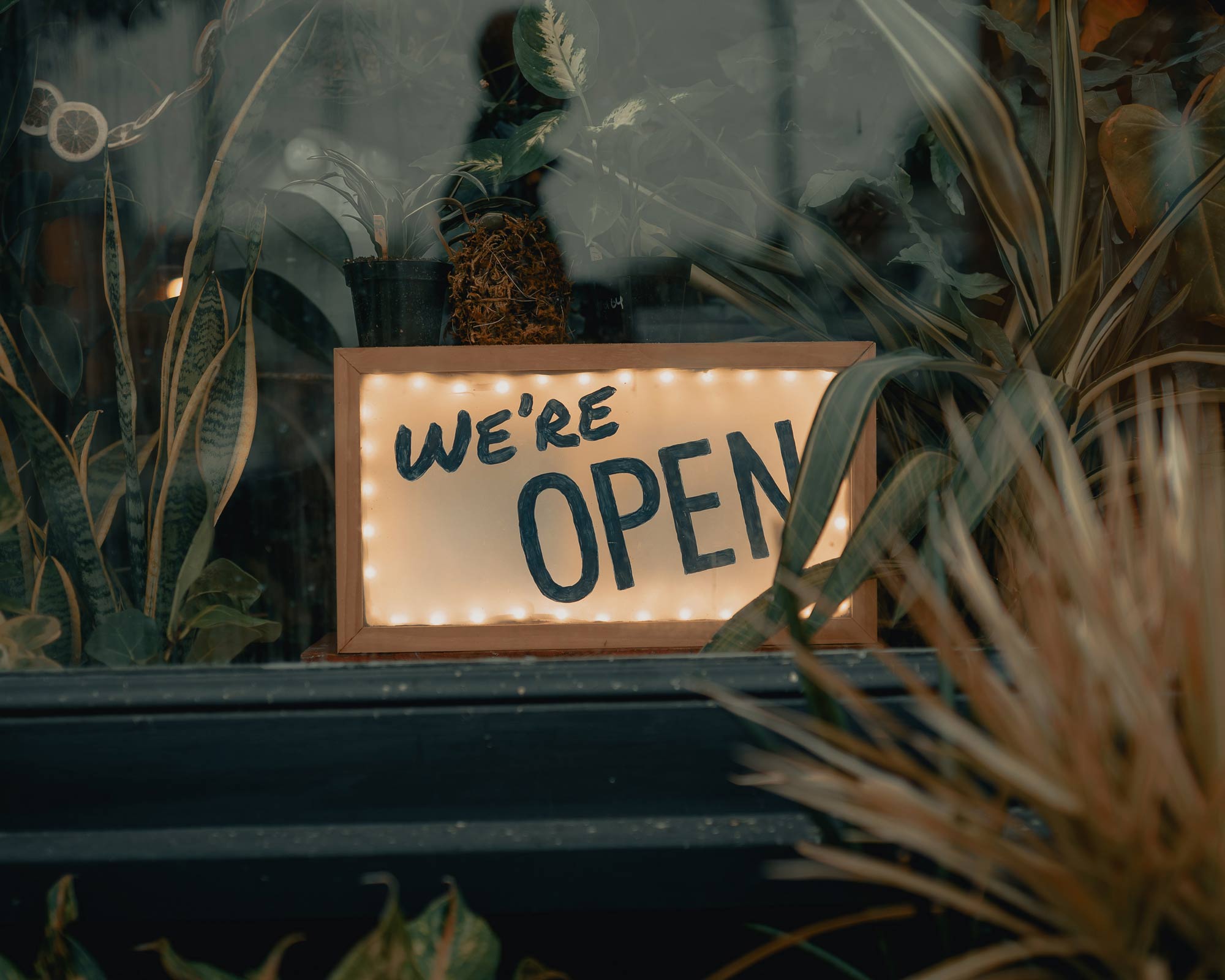 A handwritten 'We're open' sign in a shop window