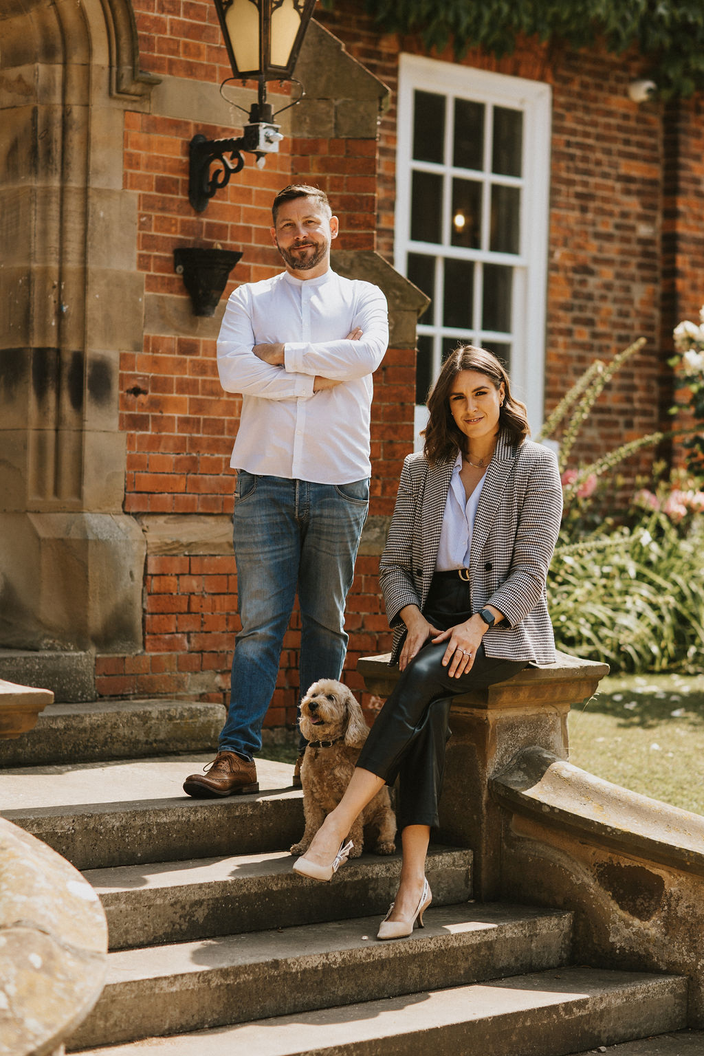 Two of the team on the front steps of Healing Manor Hotel, with a dog